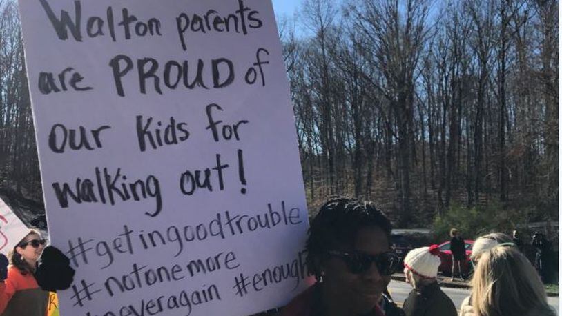 Walton High School parents showed up at the Cobb County school Wednesday to cheer  their children's walkout to honor the Parkland victims and decry gun violence.