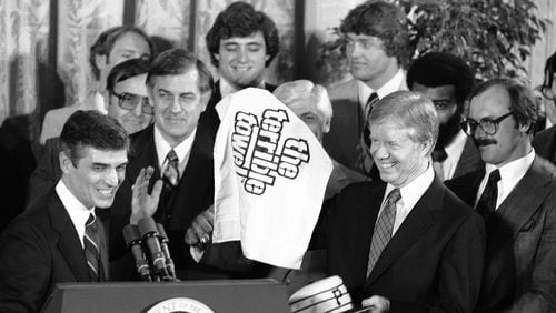 President Jimmy Carter holds a Pittsburgh Pirates cap and a Pittsburgh Steelers "Terrible towel" as he meets both champion teams at the White House in Washington on Feb. 22, 1980.