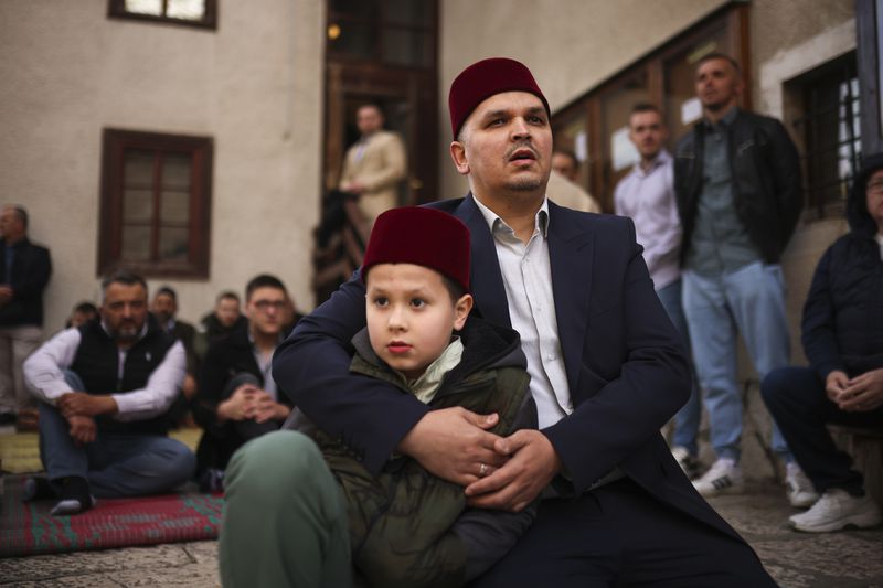 A Bosnian Muslim man prays with his son during the first day of Eid al-Fitr, which marks the end of the holy fasting month of Ramadan in Gazi Husrev-beg Mosque in Sarajevo, Bosnia, Wednesday, April 10, 2024. (AP Photo/Armin Durgut)