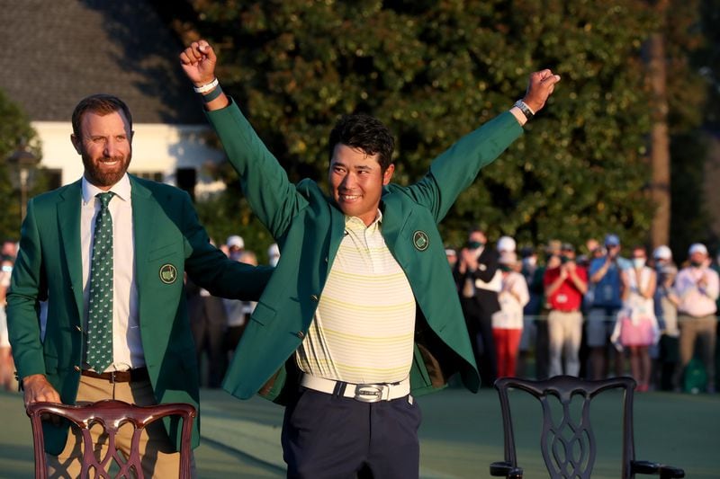 Last year's Masters champion Dustin Johnson (left) presents Hideki Matsuyama with his green jacket after winning the 85th Masters Tournament Sunday, April 11, 2021, at Augusta National Golf Club in Augusta. (Curtis Compton/ccompton@ajc.com)