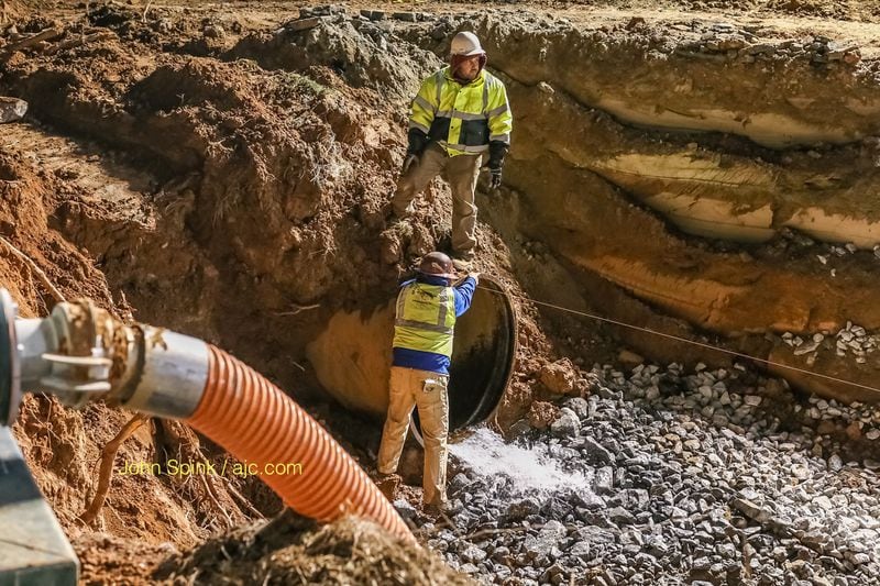 Repair work is ongoing to fix a water main that broke and led to widespread outages and flooding along Buford Highway in DeKalb County. JOHN SPINK / JSPINK@AJC.COM