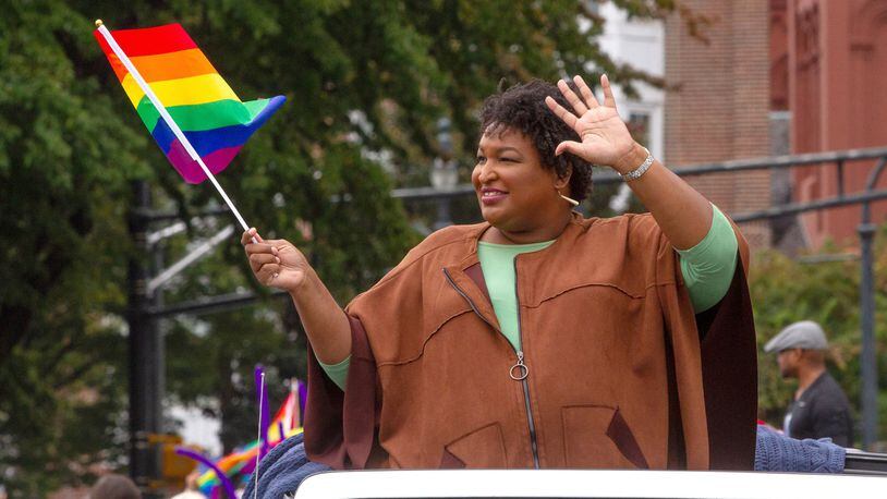 Stacey Abrams waves a rainbow flag as she makes her way down Peachtree Street during the 49th Annual Pride Festival and Parade in Atlanta Sunday, Oct 13, 2019. STEVE SCHAEFER / SPECIAL TO THE AJC