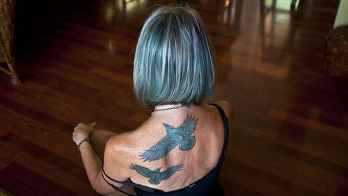 “I’m taking this journey with you,” said Lorri Stonehocker about getting two of her husband’s favorite birds tattooed on her back while posing for a photograph at her home in Spokane Valley on Thursday, Aug. 24, 2017. Her husband passed away in March 2016. She is teaching a first-time class offered through Act 2 on Healthy Grieving. (Kathy Plonka/The Spokesman-Review/TNS)