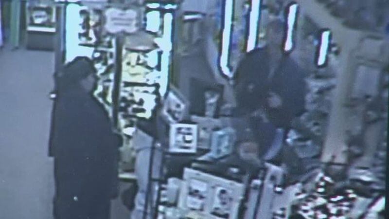 A woman distracts a Gwinnett County store owner during a robbery. (Credit: Channel 2 Action News)