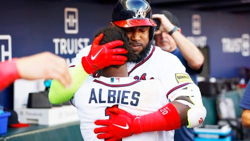 Marcell Ozuna (20) embraces Ozzie Albies (1) after hitting a solo home run during the ninth inning of Sunday's game against the Washington Nationals at Truist Park. (Miguel Martinez / miguel.martinezjimenez@ajc.com)