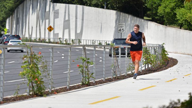 Nick Huston, of Sandy Springs, jogs on the Phase 1 stretch of PATH400 along Ga. 400 in Buckhead. Roswell supports a trail in the Ga. 400 corridor extending south to a possible link-up with PATH400 in Sandy Springs. HYOSUB SHIN / HSHIN@AJC.COM
