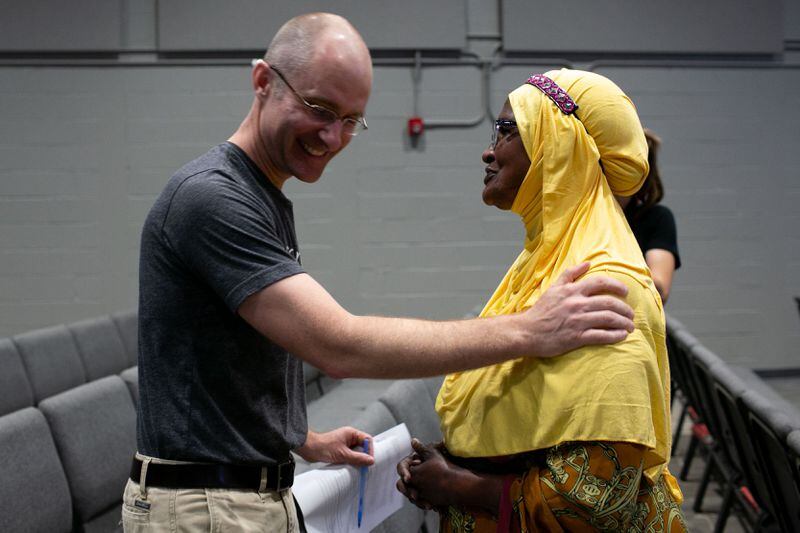 Joshua Sieweke, former office director of World Relief Atlanta, speaks to Amina Osman, a 90-year-old refugee and Clarkston resident, during Rally for Resettlement, a solidarity event for refugees and agencies, held at Clarkston International Bible Church in Clarkston, Georgia, on Saturday, Sept. 28, 2019. (Photo: Rebecca Wright / Special to the AJC)