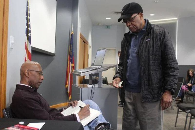 Sports writer Terence Moore signs a copy of his book for Steven Vance at the Smyrna Public Library on Saturday, Feb. 4th. (Photo Courtesy of Brian McKeithan)