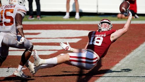 Oklahoma running back Austin Stogner (18) tries to make a one-handed catch in the end zone during the second overtime as Texas defensive back Chris Brown (15) looks on at the Cotton Bowl in Dallas on Saturday, Oct. 10, 2020. Oklahoma won in quadruple overtime, 53-45. (Tom Fox/Dallas Morning News/TNS)