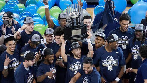 Georgia Tech guard Jose Alvarado holds the winners trophy as he and his teammates celebrate their 80-75 win over Florida State in the ACC championship game Saturday, March 13, 2021 in Greensboro, N.C. (Gerry Broome/AP)