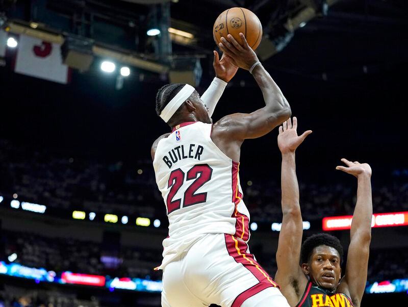 Miami Heat forward Jimmy Butler (22) shoots as Atlanta Hawks forward De'Andre Hunter defends during the first half of Game 2 of an NBA basketball first-round playoff series, Tuesday, April 19, 2022, in Miami. (AP Photo/Lynne Sladky)