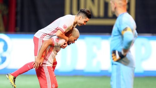 September 13, 2017 Atlanta: Atlanta United's Miguel Almiron jumps onto Josef Martinez after scoring a penalty kick for the second goal against New England on Wednesday at Mercedes-Benz Stadium.