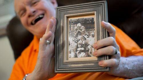 Walter Chadwick, who was a star running back at the University of Tennessee in the 1960s, holds a photo of him scoring a touchdown during a game against Tulane University. Chadwick was named head coach of Wills High School in 1971, but after being on the job just two weeks, an accident left Chadwick brain-damaged. Chadwick recently gathered with friends and former students, many of whom thought he was dead. BRANDEN CAMP / SPECIAL