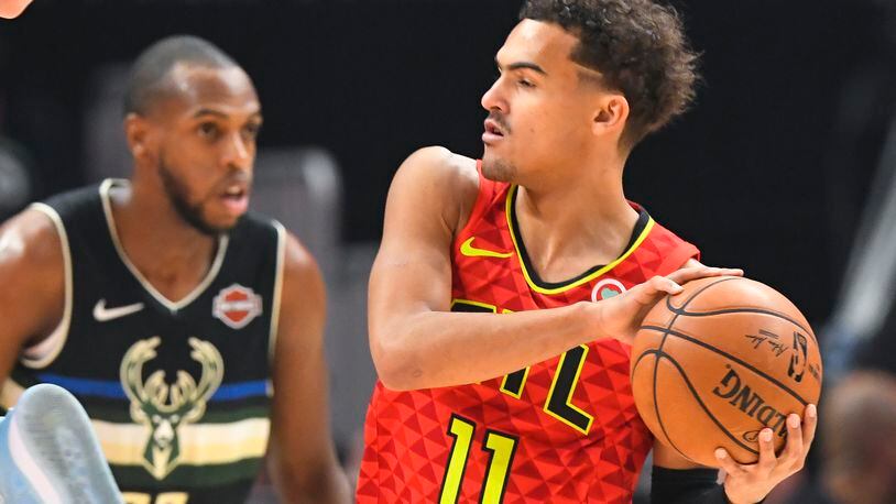 Hawks guard Trae Young (11) looks over the floor as Milwaukee Bucks forward Khris Middleton defends during the first half of an NBA basketball game Friday, Dec. 27, 2019, in Atlanta. (AP Photo/John Amis)