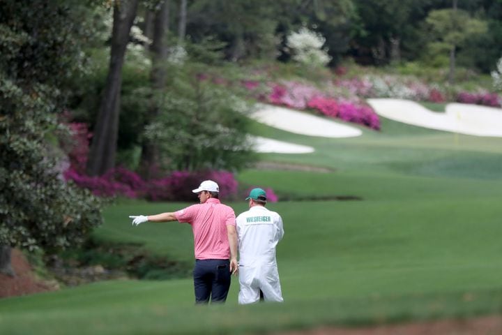 April 9, 2021, Augusta: Bernd Wiesberger confers with his caddie James Lane before his second shot on the fourteenth fairway during the second round of the Masters at Augusta National Golf Club on Friday, April 9, 2021, in Augusta. Curtis Compton/ccompton@ajc.com