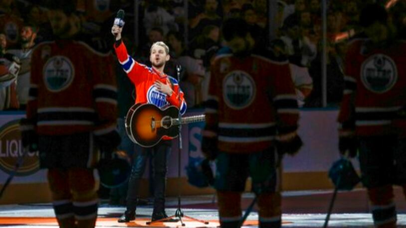 Canadian country singer Brett Kissel holds his faulty microphone up asking the crowd to help him sing the "Star-Spangled Banner" before the start of Game 3 of the NHL play-off series between the Anaheim Ducks and the Edmonton Oilers on Sunday, April 30, 2017 in Edmonton, Alberta.