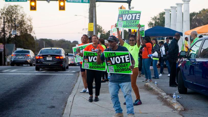 Bobby Adams (front), from the SCLC, encourages citizens to vote on Tuesday, November 8, 2022, across the street from the Metropolitan Library in Atlanta. Voters cast their ballots for the midterm elections. CHRISTINA MATACOTTA FOR THE ATLANTA JOURNAL-CONSTITUTION.