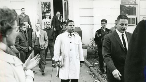 Surrounded by classmates and administrators, Hamilton Holmes Sr. begins classes at the University of Georgia in 1961. He was one of the first two black students.