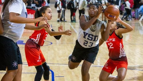 Team Impact’s Oddyssey Murray (center) tries to break through Blitz’s defense for a score during the Atlanta Hawks Youth Classic at the LakePoint Champions Center. Photo by Phil Skinner