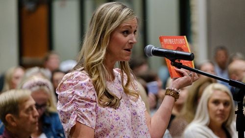 Chelle Brown holds Yaa Gyasi’s Homegoing while speaking at a Cherokee County school board meeting in Canton on Thursday, April 21, 2022. Brown and some other parents advocate for removing books they deem objectionable from Cherokee County schools. (Arvin Temkar / arvin.temkar@ajc.com)