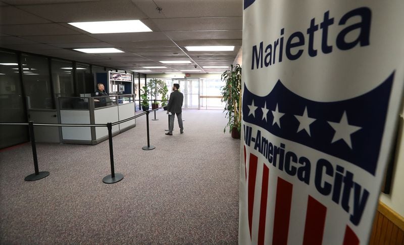 March 26, 2020 Marietta: The Marietta City Hall is open for business, but the lobby is mostly quiet and a six foot barrier seperates Marietta Police Officer Chris Rader from visitors on Thursday, March 26, 2020, in Marietta. A patchwork of local officials, not the governor or president, this week ordered the closure of businesses across the state and forced people to shutter inside their homes over fears of COVID-19.       Curtis Compton ccompton@ajc.com