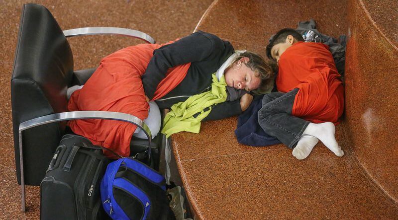 Laurie Thurston and her son, Jacob, spent the night in the airport's atrium. JOHN SPINK/jspink@ajc.com