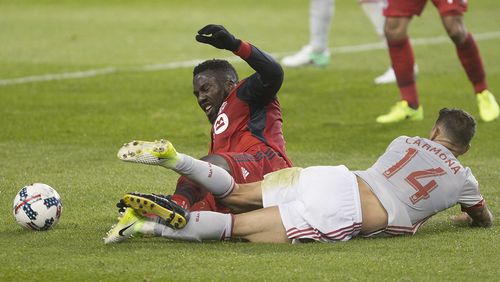 Toronto FC forward Jozy Altidore is brought down by Atlanta United midfielder Carlos Carmona (14) during the first half of an MLS soccer match Saturday, April 8, 2017, in Toronto. (Chris Young/The Canadian Press via AP)
