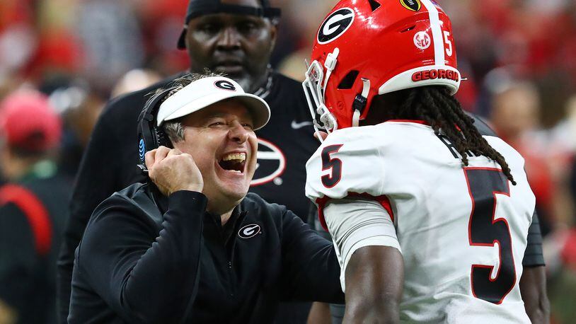 Georgia head coach Kirby Smart reacts with defensive back Kelee Ringo after he intercepted a Alabama quarterback Bryce Young pass and returner it for a touchdown for a 33-18 lead and the victory over Alabama during the 4th quarter in the College Football Playoff Championship game on Monday, Jan. 10, 2022, in Indianapolis.  Curtis Compton / Curtis.Compton@ajc.com