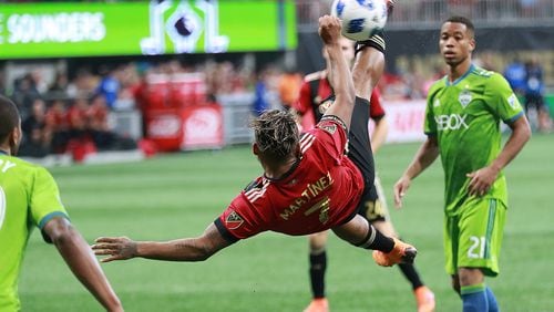 Atlanta United striker Josef Martinez attempts a bicycle kick against the Seattle Sounders that goes wide with Jordy Delem looking on during the second half in a MLS soccer game on Sunday, July 15, 2018, in Atlanta. Martinez scored his team’s only goal in a 1-1 tie.     Curtis Compton/ccompton@ajc.com