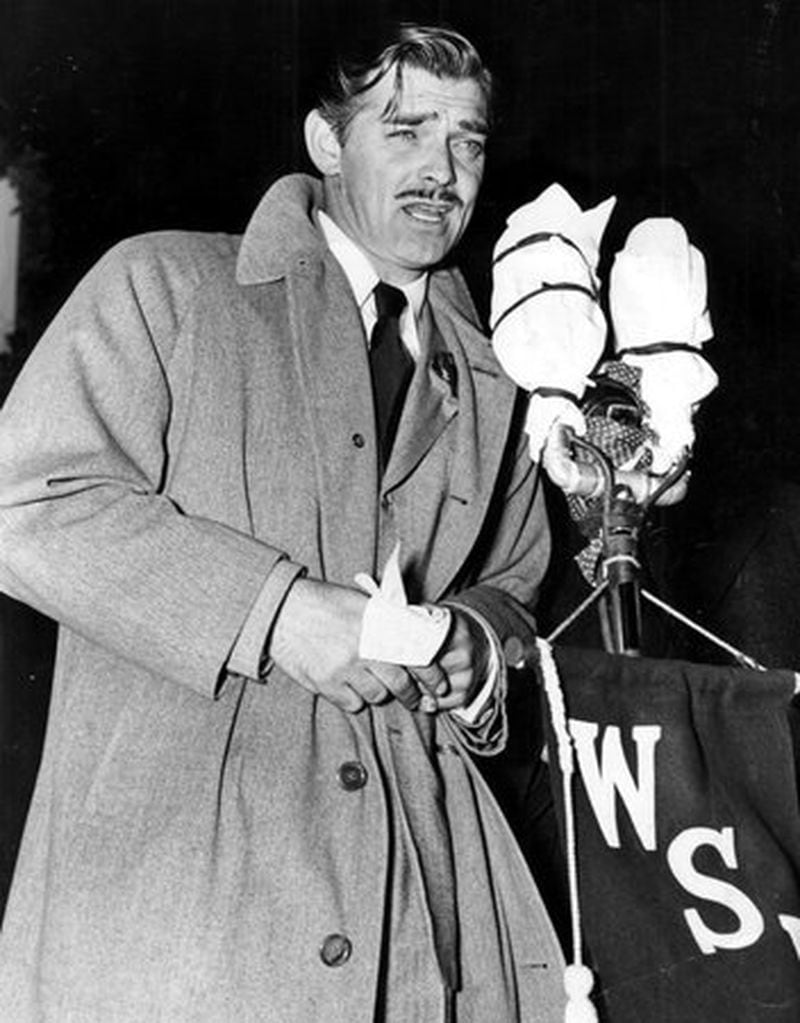 Clark Gable at the microphone addressing the crowd on the WSB radio platform in front of the Georgian Terrace Hotel on Peachtree Street for the premiere of "Gone With the Wind" in December 1939. AJC FILE
