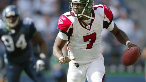 Falcons quarterback Michael Vick looks for a receiver while scrambling under pressure from Seattle Seahawks’ Bryce Fisher (94) during the second quarter in Seattle Sunday, Sept. 18, 2005. (AP Photo/John Froschauer)