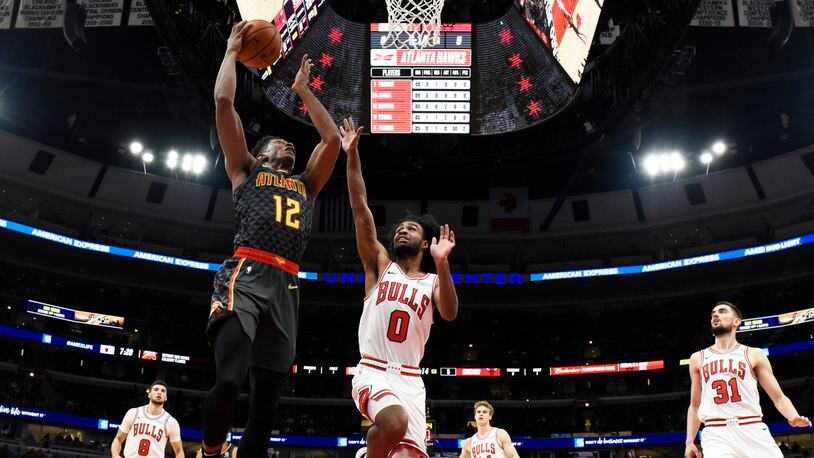 Hawks forward De'Andre Hunter (12) goes to the basket as Chicago Bulls guard Coby White (0) defends. (AP Photo/David Banks)