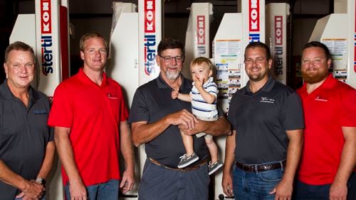 His Duluth-based heavy lift company is a family business for former Falcon Jeff Merrow (center). He is flanked, from far left, by his brother David Merrow, sons Jeffrey, Ian and Thor.  He's holding grandson Colin.
