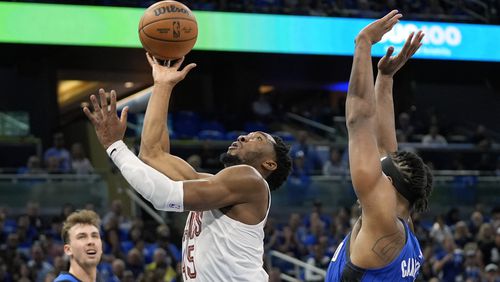 Cleveland Cavaliers guard Donovan Mitchell, center, shoots as he gets past Orlando Magic center Wendell Carter Jr., right, during the first half of Game 6 of an NBA basketball first-round playoff series, Friday, May 3, 2024, in Orlando, Fla. (AP Photo/John Raoux)
