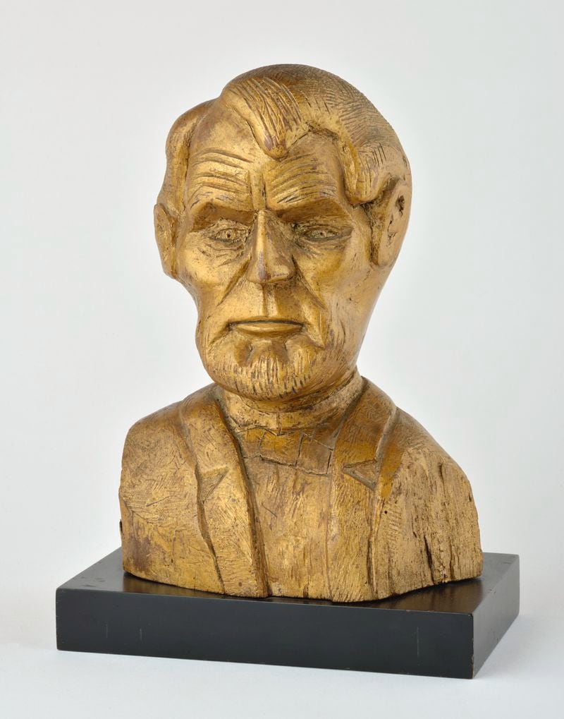 An American carved wooden bust portrait depicting Abraham Lincoln with allover gilt enrichment on ebonized base, circa early 20th century, was created by an unidentified artist. This piece is at the High Museum of Art, Atlanta, and a gift from the Levine Folk Art Collection. Courtesy of Kenneth Kast