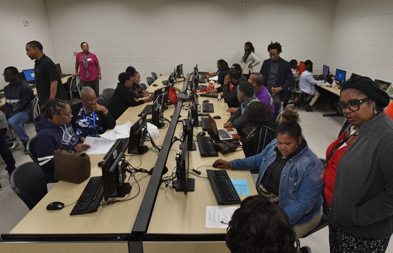 Many students and parents including Myeshia Barrett (foreground center), 18, and her mother Ieshia Barrett (foreground) fill out application for Federal Student Aid during Achieve Atlanta FAFSA Clinic at Therrell High School in Atlanta on Tuesday, October 23, 2018. HYOSUB SHIN / HSHIN@AJC.COM