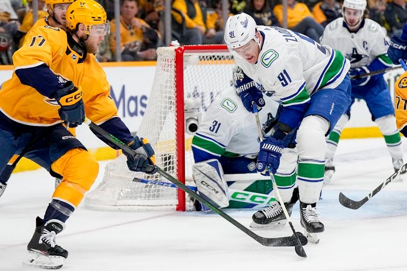 Nashville Predators center Mark Jankowski (17) tries to get the puck past Vancouver Canucks defenseman Nikita Zadorov (91) during the second period in Game 6 of an NHL hockey Stanley Cup first-round playoff series Friday, May 3, 2024, in Nashville, Tenn. (AP Photo/George Walker IV)