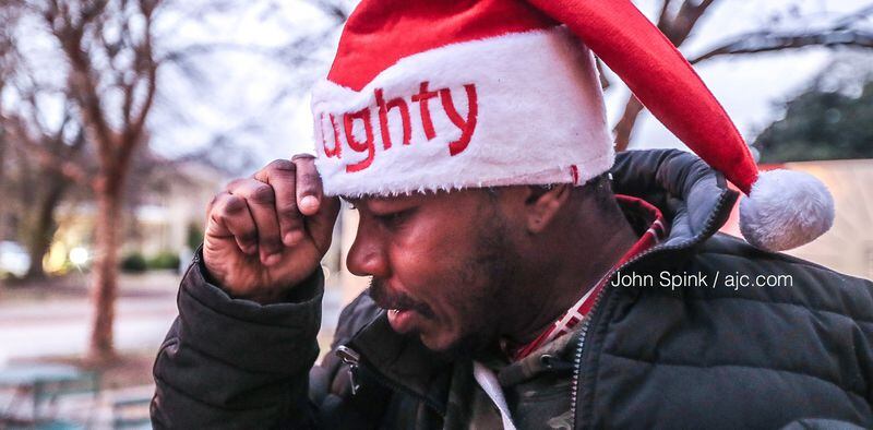 James Youngblood felt the chill on 15th and Peachtree streets as he adjusted his "Naughty" Santa hat Tuesday morning.