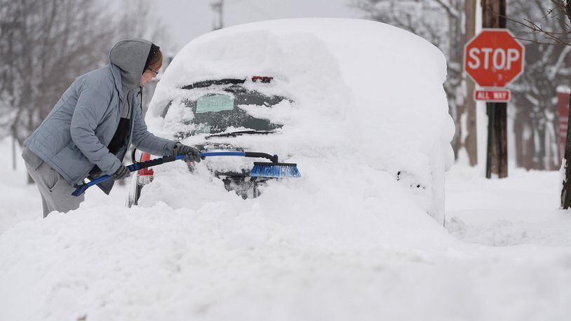 Chelse Volgyes clears snow from her car in Erie, Pa., Wednesday, Dec. 27, 2017. Freezing temperatures and below-zero wind chills socked much of the northern United States on Wednesday, and the snow-hardened city of Erie, dug out from a record snowfall.