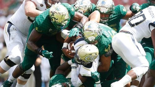 Georgia Tech quarterback TaQuon Marshall (16) runs the ball while tackled by South Florida linebacker Nico Sawtelle (54) and a host of other Bulls during the first half at Raymond James Stadium in Tampa, Fla., on Saturday, Sept. 8, 2018. South Florida won, 49-38. (Octavio Jones/Tampa Bay Times/TNS)