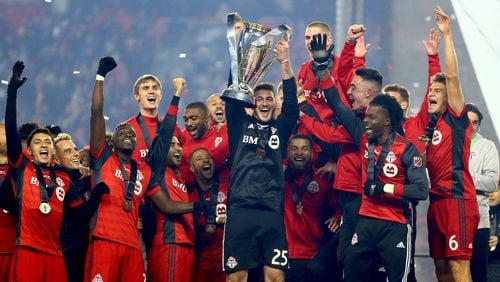 TORONTO, ON - DECEMBER 09:  Alex Bono #25 of Toronto FC lifts the Championship Trophy after winning the 2017 MLS Cup Final against the Seattle Sounders at BMO Field on December 9, 2017 in Toronto, Ontario, Canada.  (Photo by Vaughn Ridley/Getty Images)