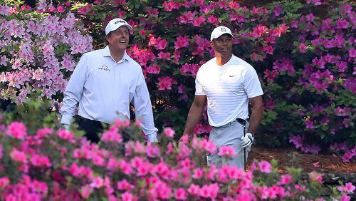 Tiger Woods and Phil Mickelson tee off on the 13th hole while playing a practice round together for the Masters at Augusta National Golf Club on Tuesday.