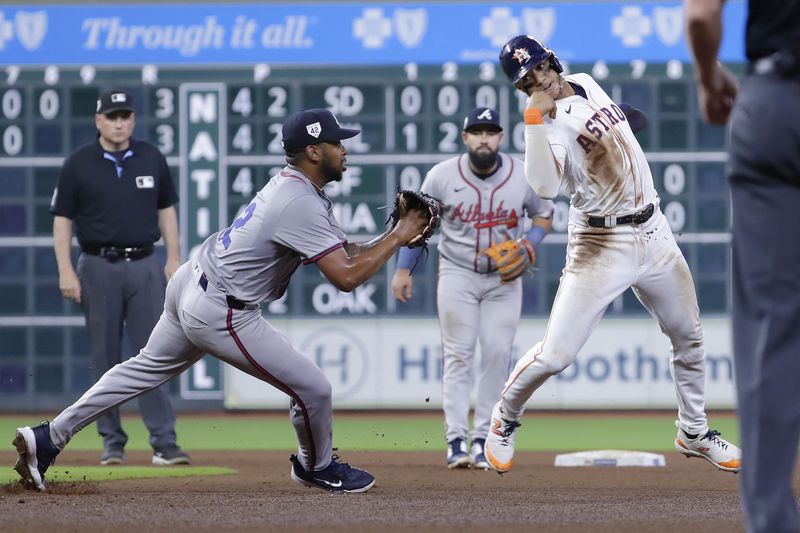 After getting caught in a pickle while trying to steal second base, Houston Astros runner Jeremy Pena, right, avoids a tag by Atlanta Braves second baseman Ozzie Albies, left, but is called out for leaving the baseline, to end the fourth inning of a baseball game Monday, April 15, 2024, in Houston. (AP Photo/Michael Wyke)