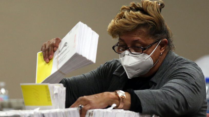 A woman sorts ballots at the DeKalb County Elections Office in Decatur, Georgia, on Wednesday, January 6, 2021. (Rebecca Wright for the Atlanta Journal-Constitution)