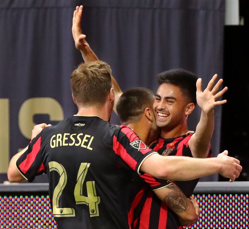 Atlanta United midfielder Pity Martinez (right) celebrates with Hector Villalba (left) and Julian Gressel after scoring his goal against Orlando City for a 1-0 lead Sunday, May 12, 2019, in Atlanta.  