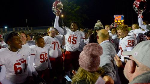 Lowndes's Travion Pope (45) raises his helmet in celebration with Viking teammates after their 21-13 win over North Cobb Friday, December 4, 2020 in Kennesaw. (PHOTO/Daniel Varnado)