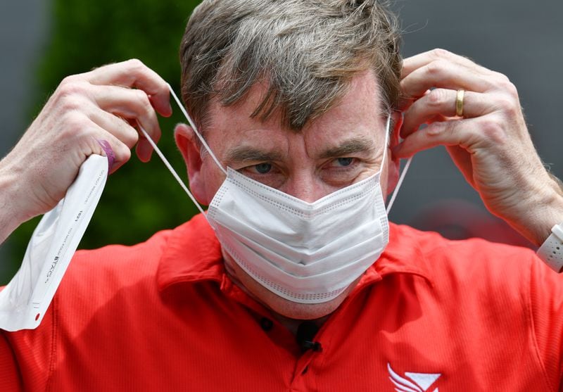 Rich Kenah, executive director of Atlanta Track Club, showcases the facemask that will be attached to race bibs of the 2021 AJC Peachtree Road Race.  (Hyosub Shin / Hyosub.Shin@ajc.com)