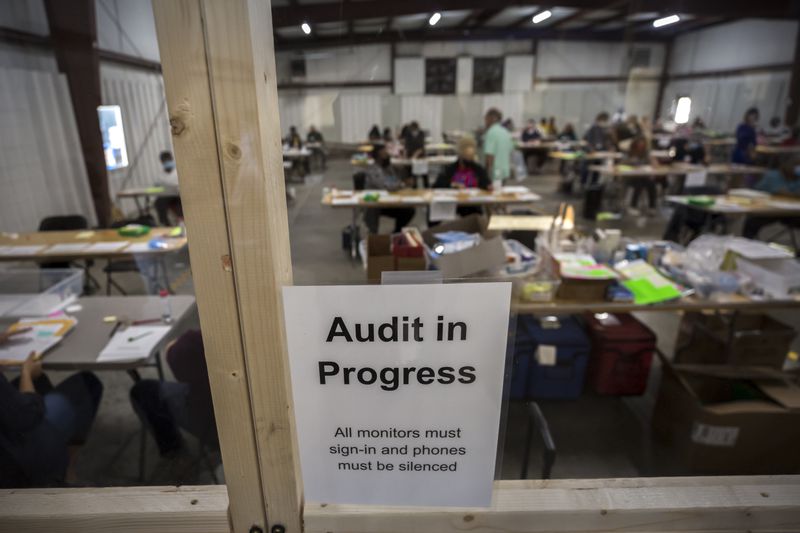 Chatham County Board of Elections officials post signs in November 2020 in the public viewing area of the Savannah office during the statewide audit of ballots from that year's presidential election. (Stephen B. Morton for The Atlanta Journal-Constitution)