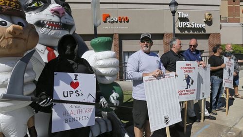 UPS aircraft mechanics hold a protest outside a UPS Store in Atlanta on Tuesday as they push to keep their level of health benefits in contract negotiations. BOB ANDRES /BANDRES@AJC.COM