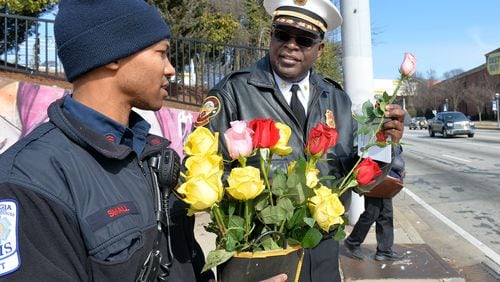 Sgt. Brenton Small and Interim Chief Joel Baker talk before handing out roses to motorists in this 2015 file image.